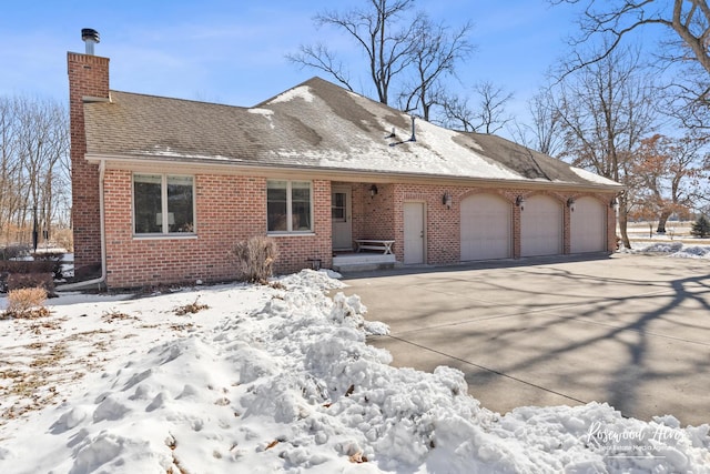 view of front of house with an attached garage, brick siding, a shingled roof, concrete driveway, and a chimney