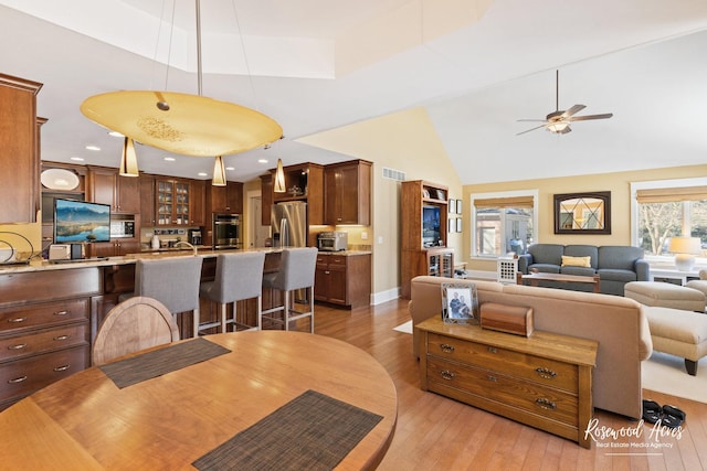 dining space with ceiling fan, high vaulted ceiling, light wood-style flooring, and recessed lighting