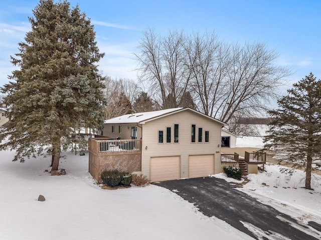 view of front of property with a garage, aphalt driveway, and a wooden deck