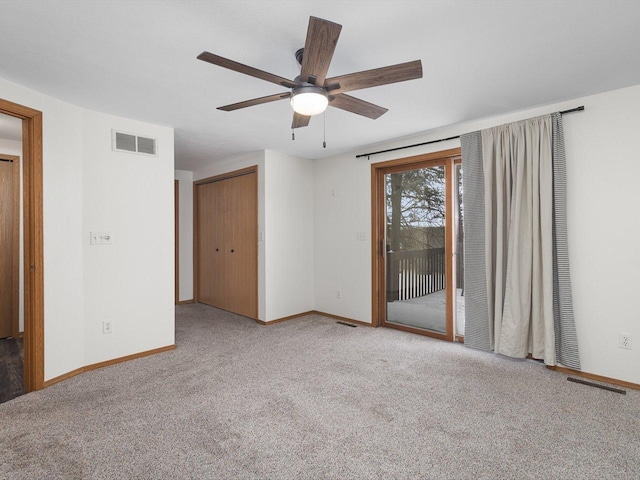 spare room featuring baseboards, visible vents, and carpet flooring