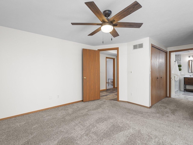 unfurnished bedroom with carpet, visible vents, baseboards, and ensuite bathroom