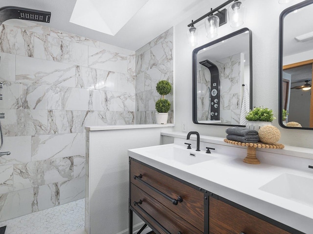 full bath with a skylight, a sink, a marble finish shower, and double vanity