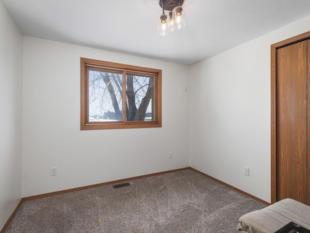 unfurnished bedroom featuring carpet, visible vents, and baseboards