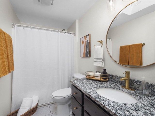 bathroom with a skylight, visible vents, toilet, vanity, and tile patterned floors