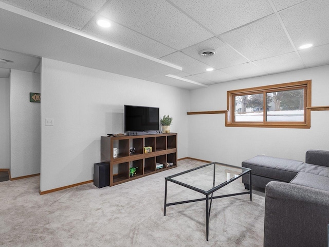 living area featuring a paneled ceiling, baseboards, and carpet flooring