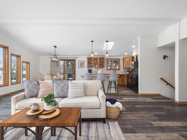 living room featuring lofted ceiling, baseboards, and dark wood-style flooring