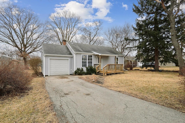 view of front facade with a deck, aphalt driveway, an attached garage, a front lawn, and a chimney