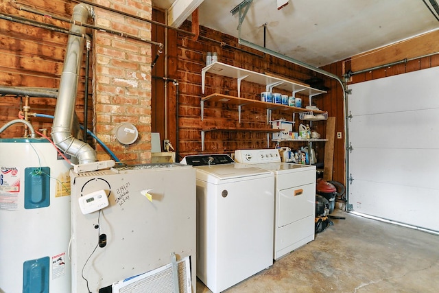 washroom featuring a garage, laundry area, electric water heater, and washer and dryer