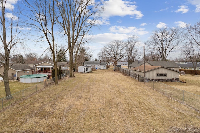 view of yard featuring a fenced backyard, a residential view, and a covered pool