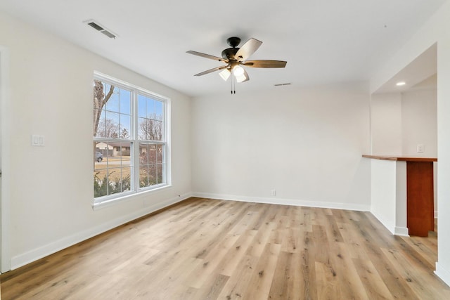 interior space with light wood finished floors, a ceiling fan, visible vents, and baseboards