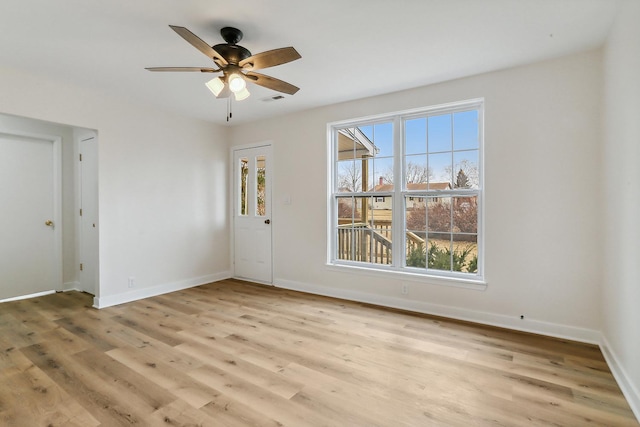 empty room with visible vents, light wood-style flooring, and baseboards