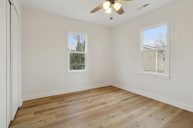 spare room featuring visible vents, ceiling fan, light wood-style flooring, and baseboards