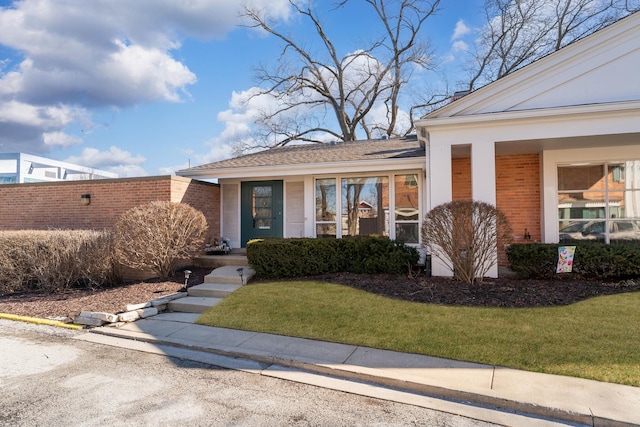 view of front of property featuring a front yard and brick siding