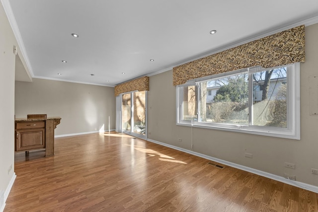 unfurnished living room featuring visible vents, ornamental molding, wood finished floors, recessed lighting, and baseboards