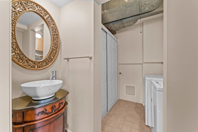 bathroom with vanity, visible vents, and washer and clothes dryer