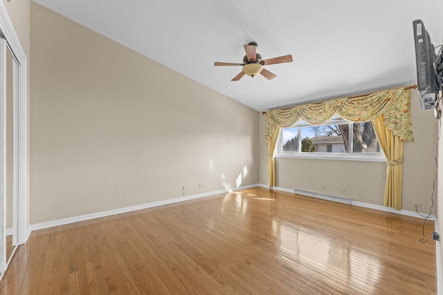 interior space featuring lofted ceiling, hardwood / wood-style floors, a closet, a baseboard radiator, and baseboards