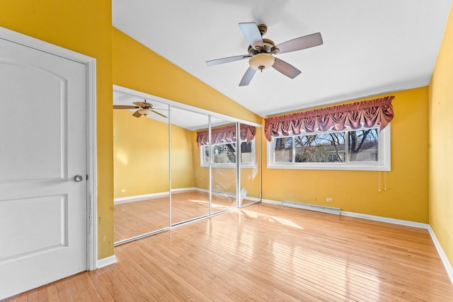 unfurnished bedroom with lofted ceiling, a ceiling fan, hardwood / wood-style floors, baseboards, and baseboard heating