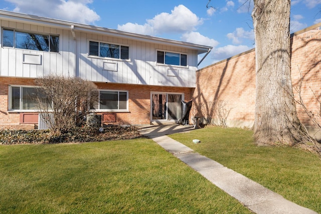 view of front of property featuring brick siding and a front lawn