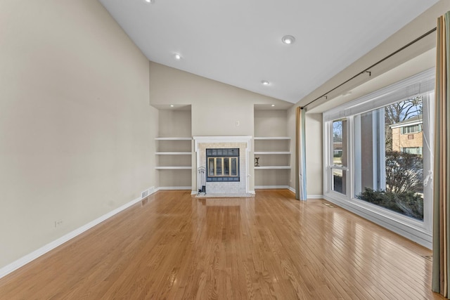 unfurnished living room featuring visible vents, lofted ceiling, light wood-style floors, and baseboards