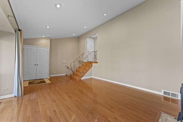 foyer entrance featuring light wood finished floors, visible vents, baseboards, stairway, and recessed lighting