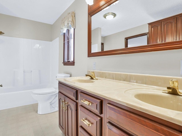 full bathroom featuring a sink, bathing tub / shower combination, toilet, and double vanity