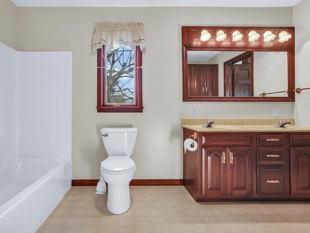 bathroom with double vanity, baseboards, toilet, tile patterned floors, and a sink