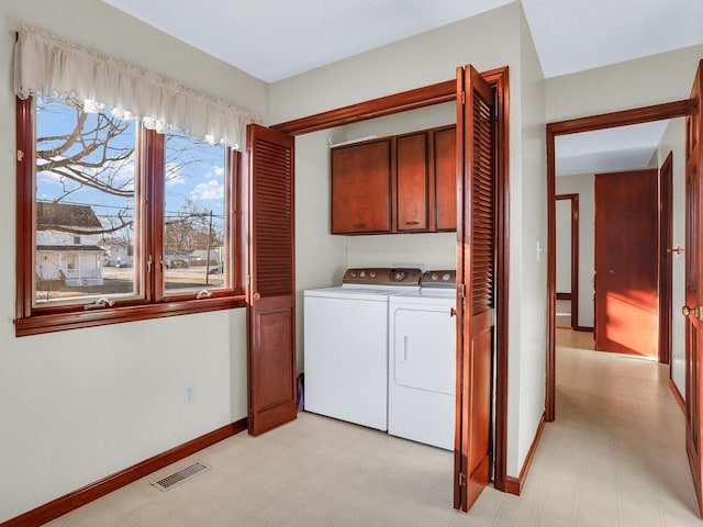 washroom featuring cabinet space, visible vents, independent washer and dryer, and light floors