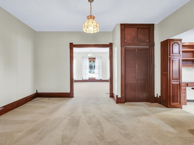 interior space featuring baseboards and light colored carpet