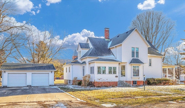 view of front of house with a garage, roof with shingles, a chimney, and an outdoor structure