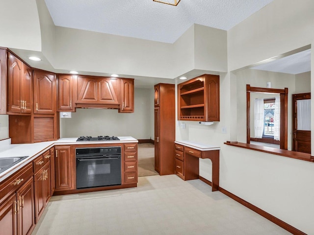 kitchen with brown cabinets, custom exhaust hood, light countertops, and oven