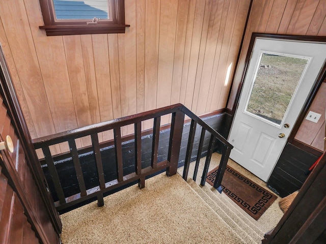 stairway featuring wood walls