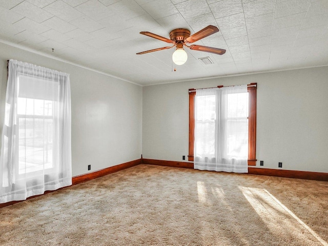 spare room with visible vents, carpet, a ceiling fan, and baseboards