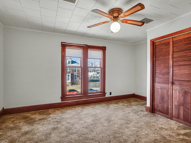 unfurnished bedroom featuring ornamental molding, light colored carpet, visible vents, and baseboards