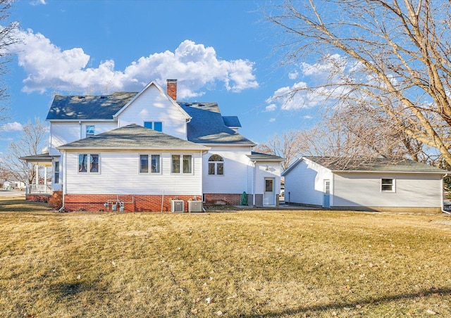 back of house featuring a yard, a chimney, and central AC unit