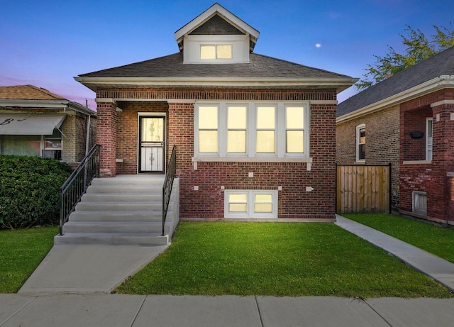 bungalow featuring brick siding and a front lawn