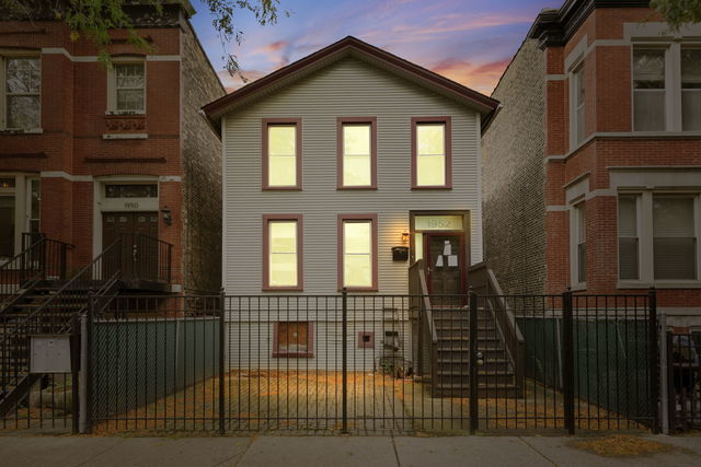 view of front of home with a fenced front yard and a gate