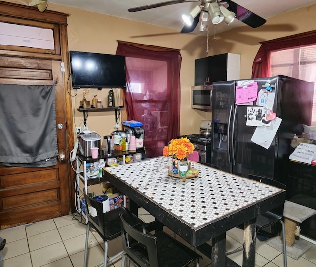 kitchen featuring appliances with stainless steel finishes, a ceiling fan, and light tile patterned floors