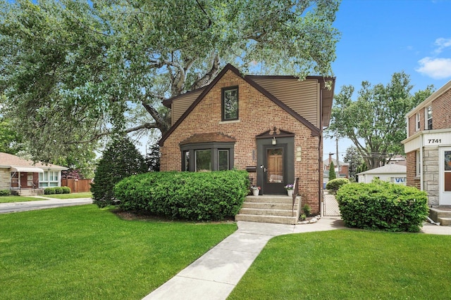 7733 W Rosedale Ave, Chicago, IL 60631 - tudor-style house with a front yard and brick siding