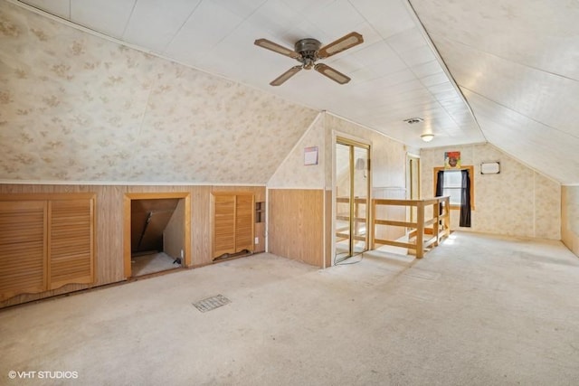 additional living space featuring lofted ceiling, light carpet, ceiling fan, and wallpapered walls