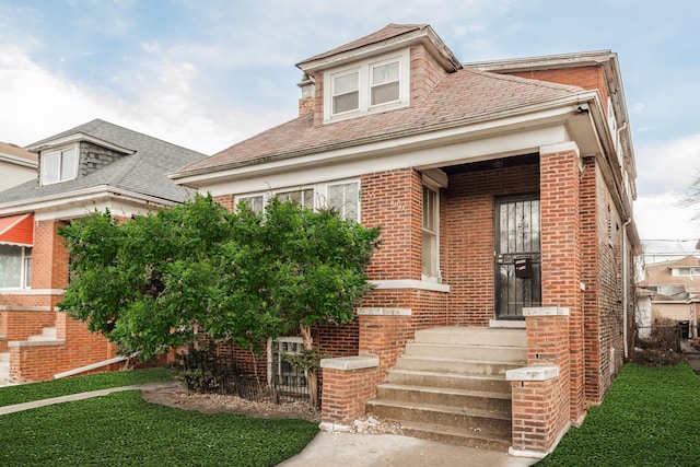 view of front of house with brick siding and a front lawn