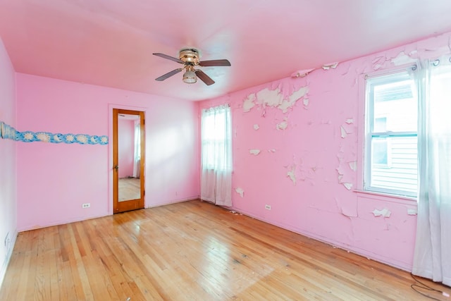 unfurnished room with a ceiling fan and light wood-style floors