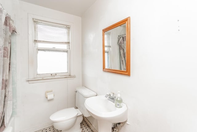 bathroom with shower / bath combo, a sink, and toilet