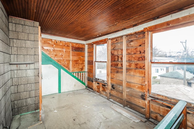 miscellaneous room with wooden ceiling and unfinished concrete floors