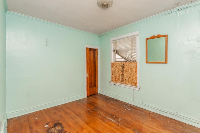 empty room featuring ornamental molding and dark wood-style flooring