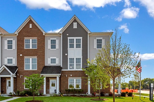 multi unit property featuring brick siding and a front yard