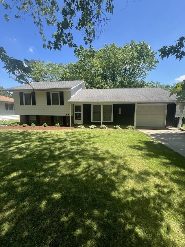 split level home with an attached garage, driveway, and a front lawn