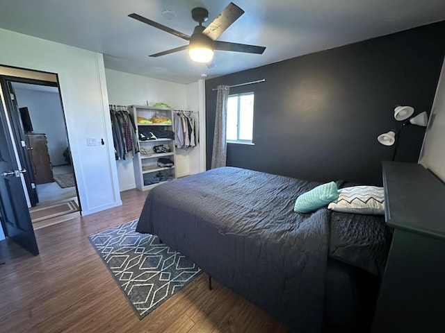 bedroom featuring dark wood-style floors, ceiling fan, and baseboards