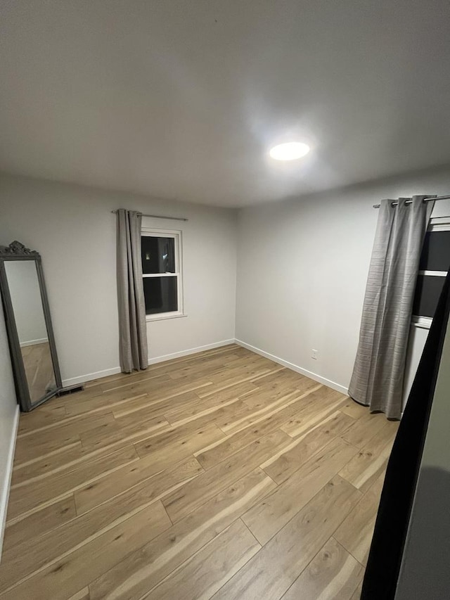 unfurnished room featuring light wood-style flooring and baseboards