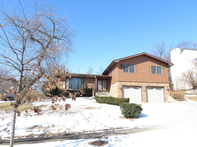 split level home with a garage and brick siding