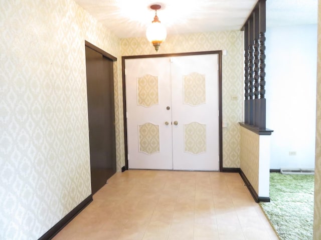 hall with wallpapered walls, visible vents, baseboards, and french doors